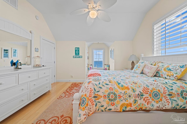 bedroom featuring ceiling fan, lofted ceiling, and light hardwood / wood-style flooring