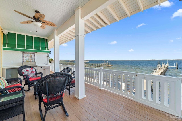 deck featuring a water view, ceiling fan, and a grill