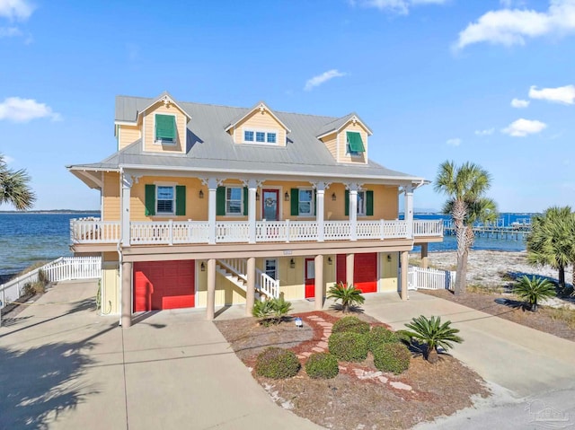 view of front of home featuring a porch, a water view, and a garage