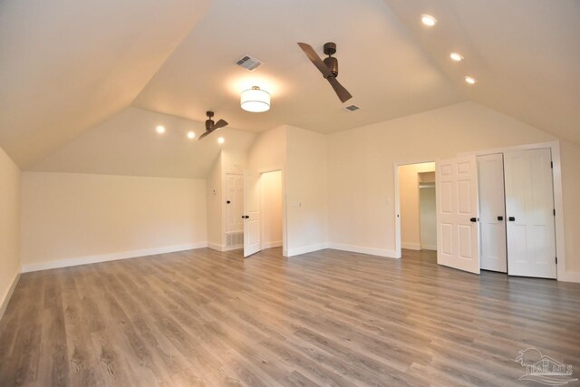 additional living space featuring wood-type flooring, vaulted ceiling, and ceiling fan