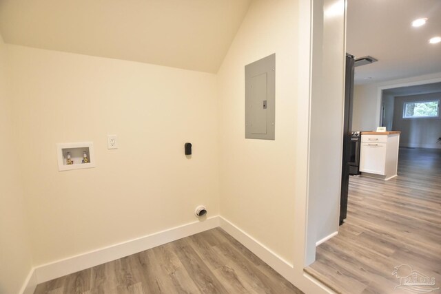 washroom with hookup for a washing machine, electric panel, and light wood-type flooring