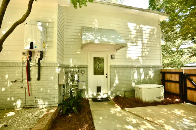 back of property with tankless water heater and a patio area