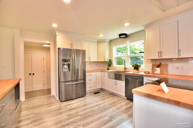 kitchen with white cabinetry, wood counters, and stainless steel fridge with ice dispenser