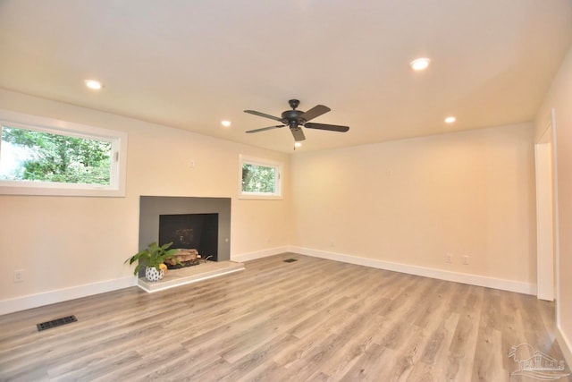 unfurnished living room featuring light hardwood / wood-style floors, ceiling fan, and plenty of natural light