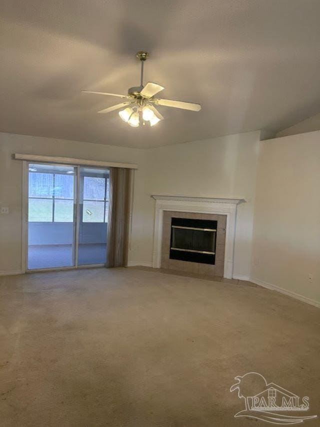 unfurnished living room with ceiling fan, a fireplace, baseboards, and light colored carpet