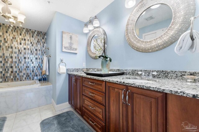 bathroom with tiled bath, tile patterned floors, and double sink vanity