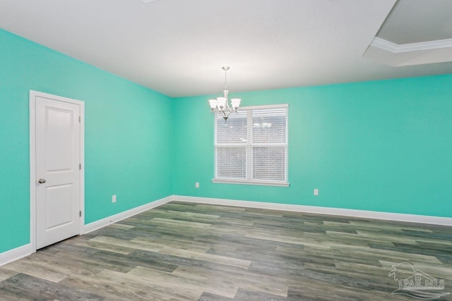 empty room with hardwood / wood-style flooring and a chandelier