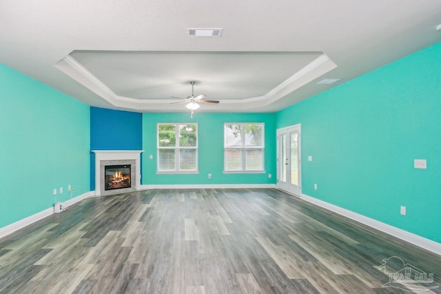 unfurnished living room featuring crown molding, a tray ceiling, ceiling fan, and hardwood / wood-style flooring