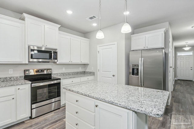 kitchen with dark hardwood / wood-style flooring, a center island, white cabinets, and appliances with stainless steel finishes