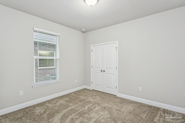 carpeted spare room featuring a textured ceiling