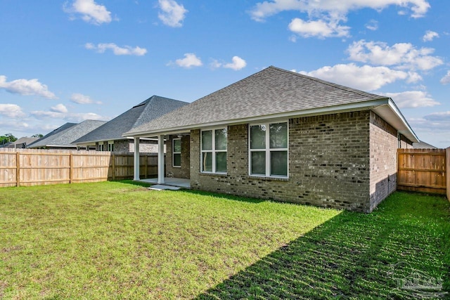 rear view of property with a yard