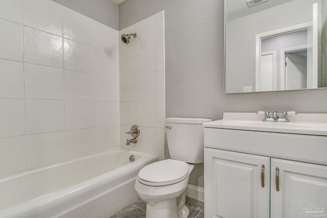 full bathroom featuring tiled shower / bath combo, toilet, and vanity