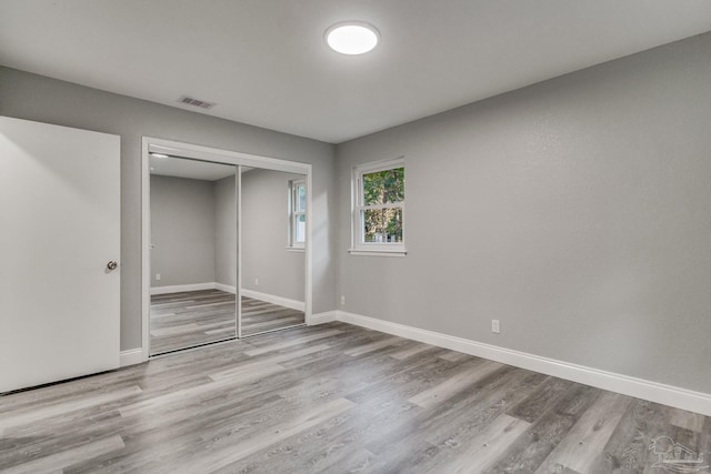 unfurnished bedroom featuring a closet and hardwood / wood-style floors