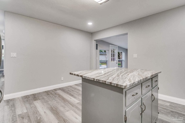 kitchen with a center island, light hardwood / wood-style floors, and gray cabinets