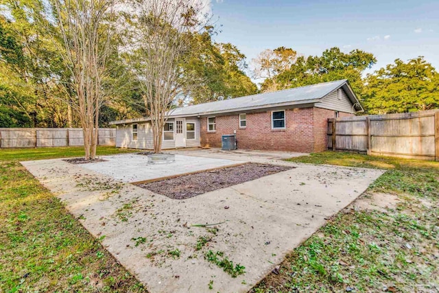 rear view of house with a lawn, cooling unit, and a patio