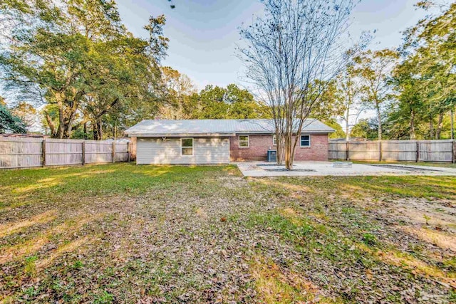 back of house with a yard and a patio area