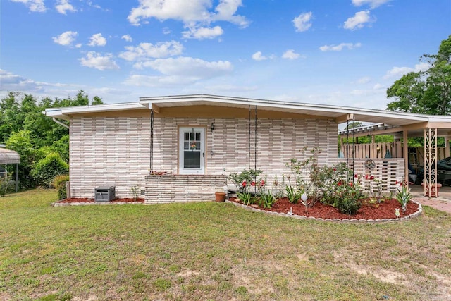 view of property exterior with central AC, brick siding, and a yard