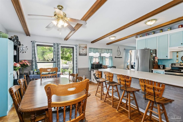 dining space with beam ceiling, a ceiling fan, and light wood-style floors
