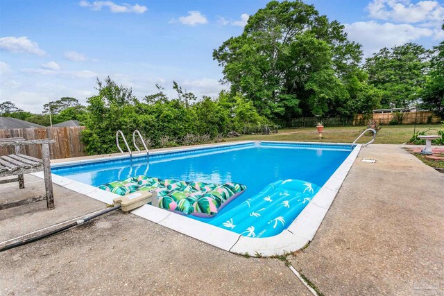 view of pool featuring a lawn, a patio, a fenced in pool, and a fenced backyard