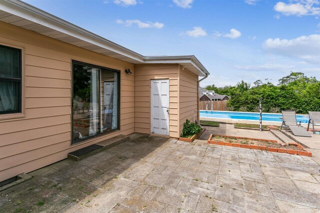 view of patio / terrace featuring fence and an outdoor pool