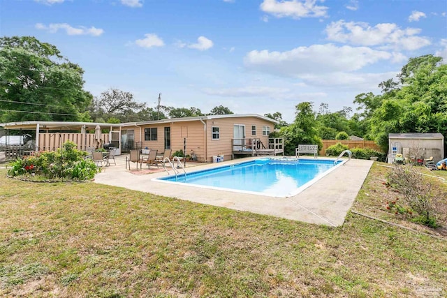 view of swimming pool with a wooden deck, a fenced in pool, a yard, a shed, and fence