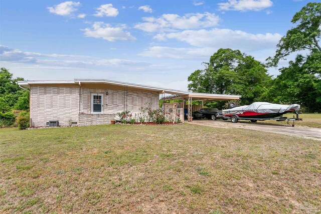 exterior space with driveway, a yard, and an attached carport