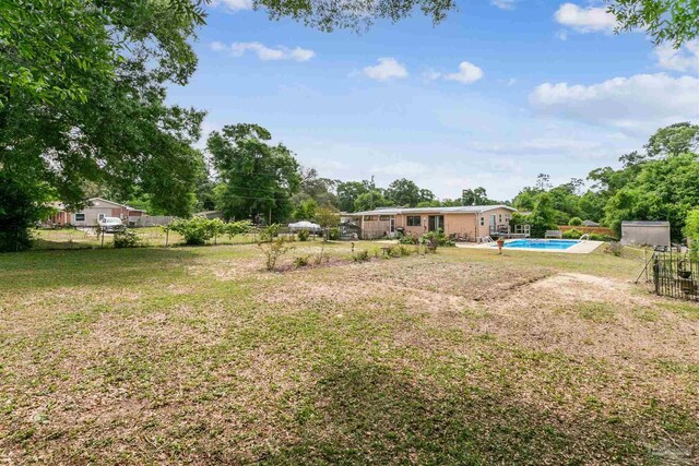 view of yard with fence and an outdoor pool