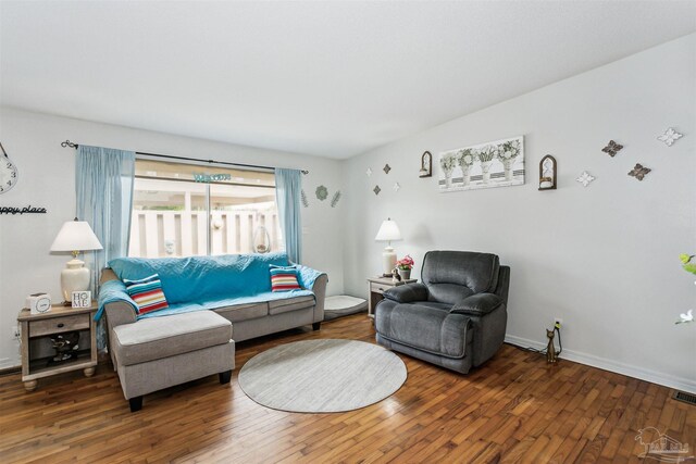 living area featuring visible vents, wood finished floors, and baseboards