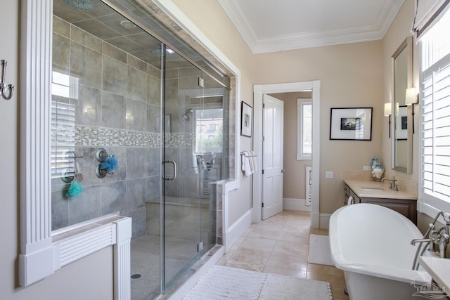 bathroom featuring crown molding, a soaking tub, vanity, a stall shower, and baseboards