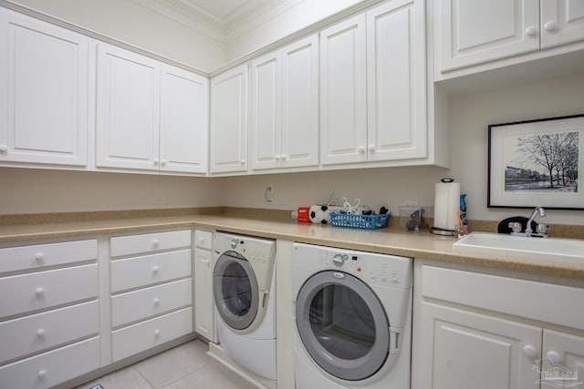clothes washing area featuring crown molding, light tile patterned floors, independent washer and dryer, a sink, and cabinet space