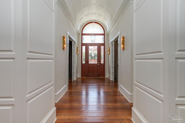 doorway with lofted ceiling, dark hardwood / wood-style flooring, and ornamental molding