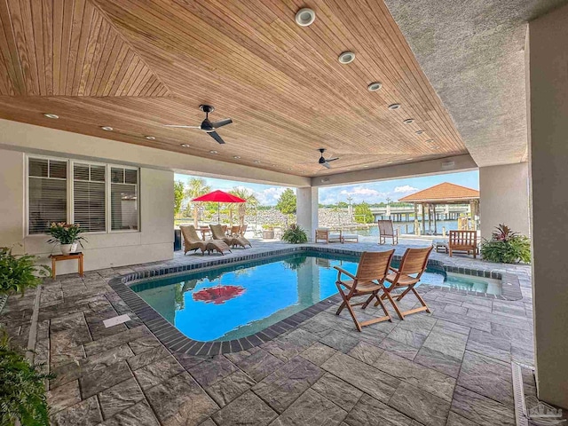 outdoor pool with a patio area, outdoor dining area, and ceiling fan
