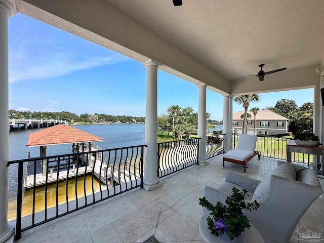 view of patio / terrace featuring a balcony, a water view, ceiling fan, and outdoor lounge area