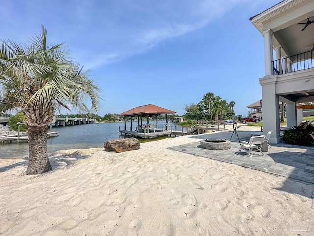 exterior space featuring a water view and a fire pit
