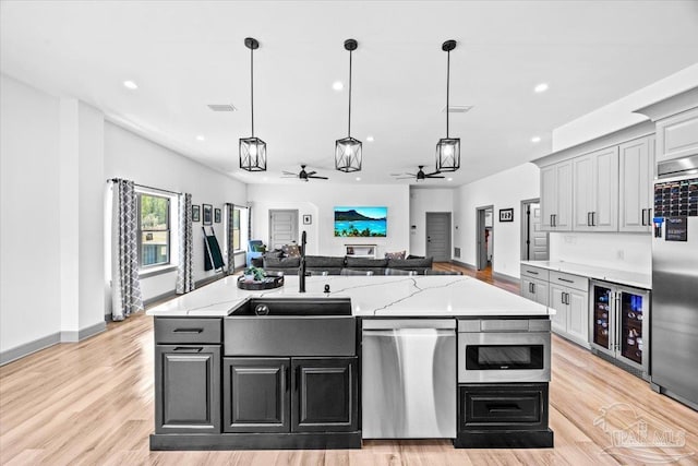 kitchen with recessed lighting, light wood-style floors, wine cooler, appliances with stainless steel finishes, and ceiling fan