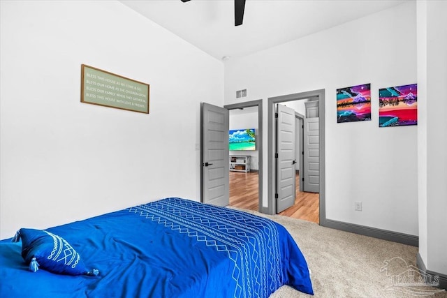 carpeted bedroom featuring visible vents, baseboards, and a ceiling fan
