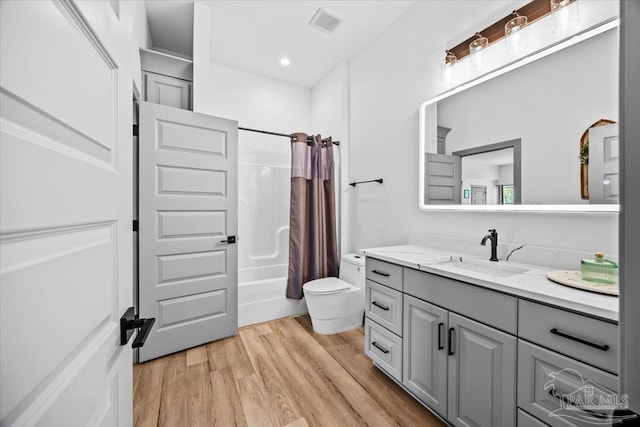 full bath with vanity, shower / tub combo with curtain, toilet, visible vents, and wood finished floors