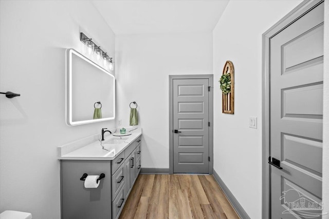 bathroom with vanity, baseboards, and wood finished floors
