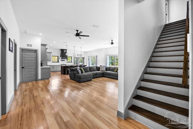 stairway featuring recessed lighting, visible vents, a ceiling fan, and wood finished floors