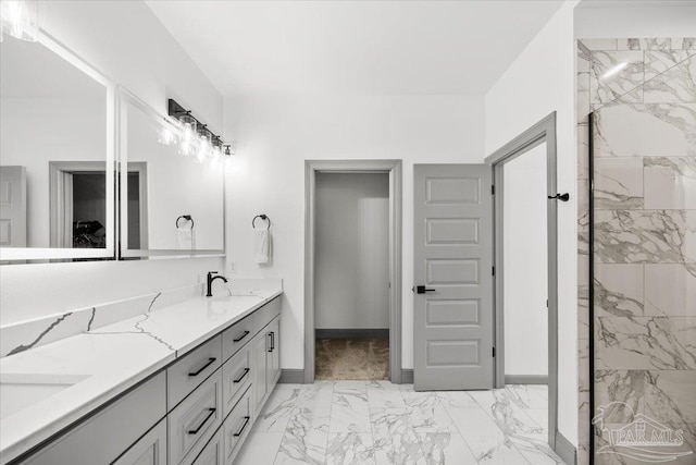 full bath featuring baseboards, walk in shower, a sink, double vanity, and marble finish floor