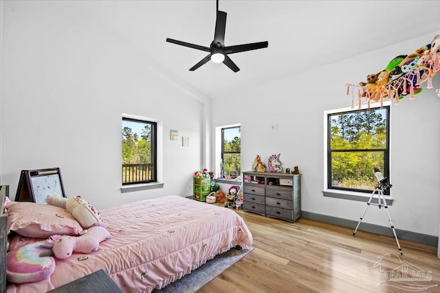 bedroom with baseboards, a ceiling fan, wood finished floors, and lofted ceiling