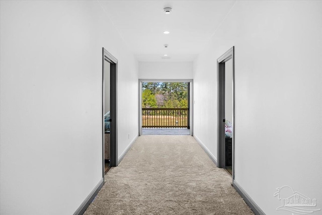 corridor with light carpet and baseboards