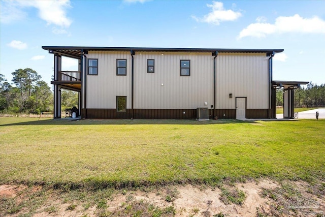 view of side of property featuring central AC unit and a lawn