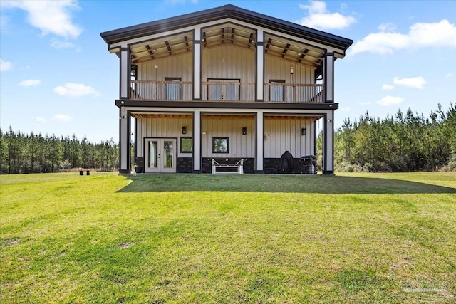 rear view of property with a yard, french doors, and board and batten siding