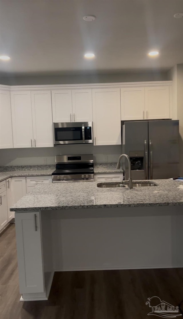 kitchen featuring light stone counters, stainless steel appliances, sink, and white cabinets