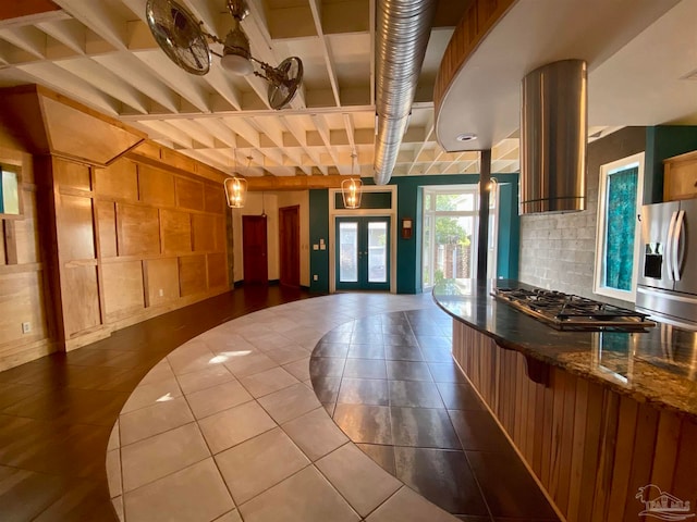 kitchen with decorative backsplash, pendant lighting, stainless steel appliances, ventilation hood, and french doors