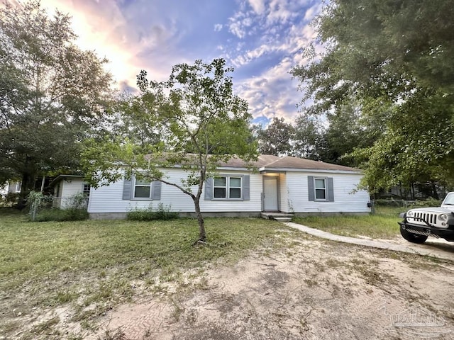 ranch-style home with a yard