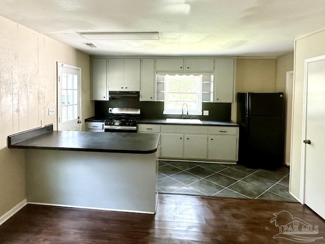 kitchen featuring a wealth of natural light, sink, stainless steel gas range oven, and kitchen peninsula