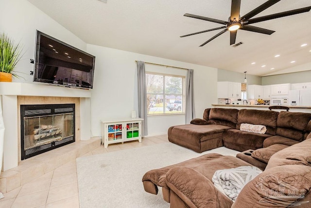 living area featuring light tile patterned floors, a ceiling fan, lofted ceiling, a fireplace, and recessed lighting