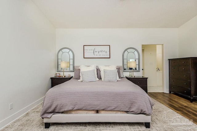 bedroom with wood finished floors and baseboards